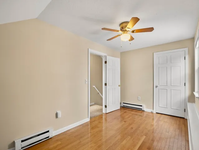 a view of a room with wooden floor and ceiling fan