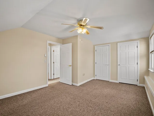 a view of a room with a ceiling fan and a fan