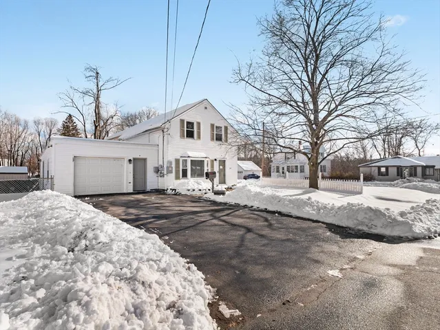a front view of a house with a yard covered in snow