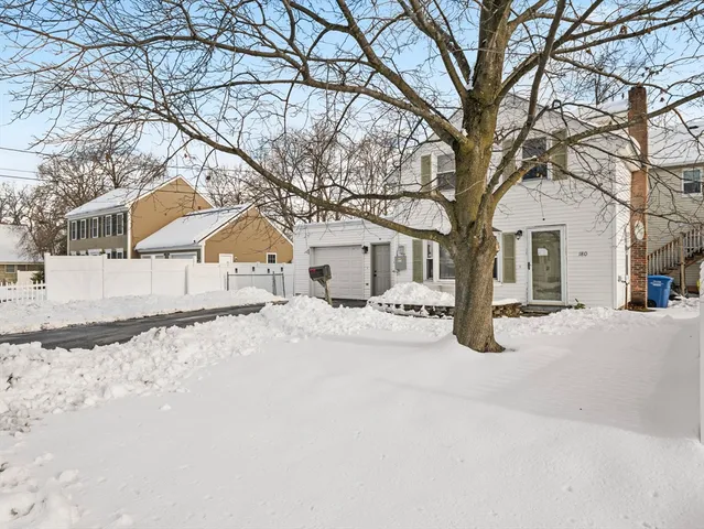 a white house that has a tree in front of it