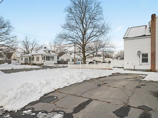 a view of white house with a snow on the road