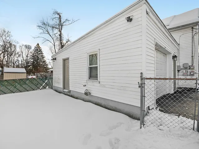 a backyard of a house with garage and trees