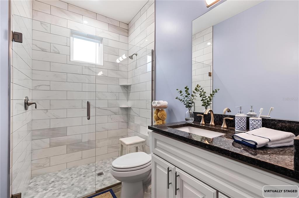 4 Uturn Court Palm Coast, FL 32164 - Photo 22 of 26 a bathroom with a granite countertop sink a toilet and a mirror