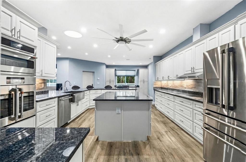 4 Uturn Court Palm Coast, FL 32164 - Photo 4 of 26 a kitchen with stainless steel appliances granite countertop a sink stove and refrigerator