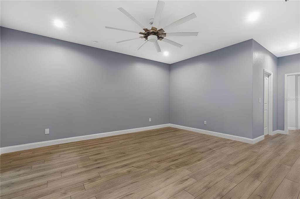 4 Uturn Court Palm Coast, FL 32164 - Photo 7 of 26 an empty room with a ceiling fan and wooden floor