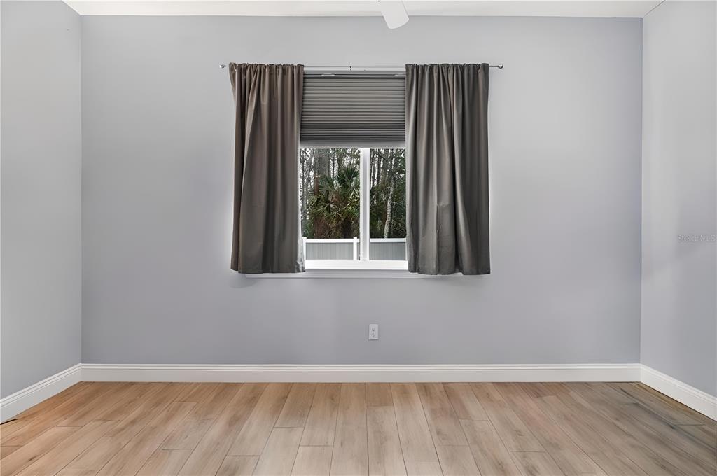 4 Uturn Court Palm Coast, FL 32164 - Photo 9 of 26 an empty room with wooden floor and windows