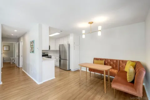 a living room with furniture and a dining table with wooden floor