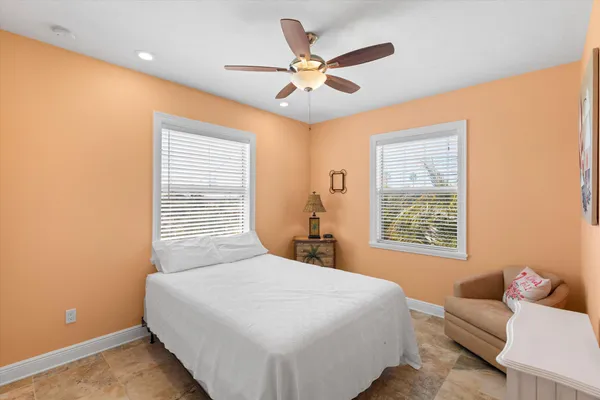 a bathroom with a granite countertop sink a toilet a mirror and shower