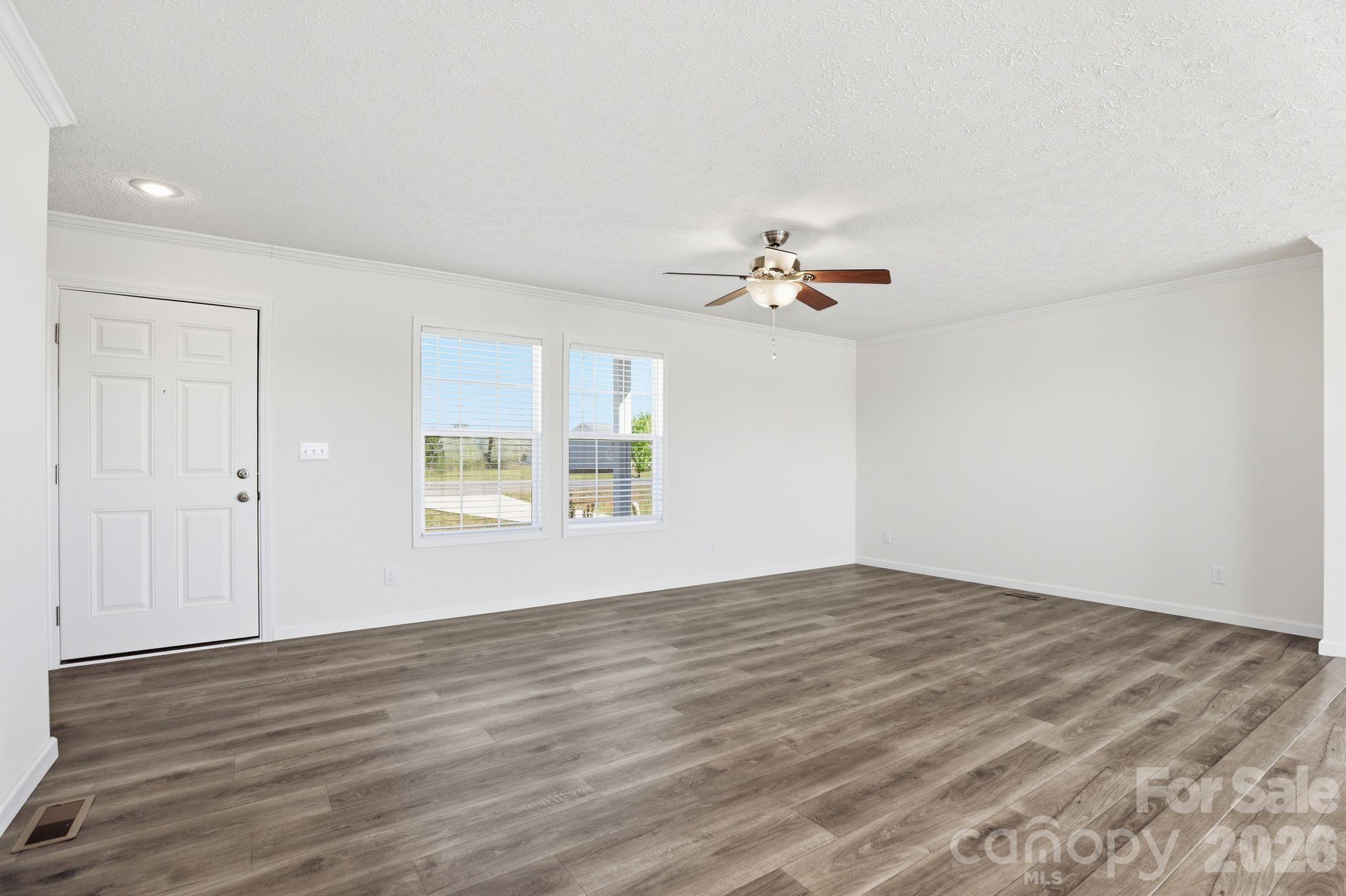 197 Burleson Point Woodleaf, NC 27054 - Photo 6 of 30 a view of an empty room with wooden floor and a window