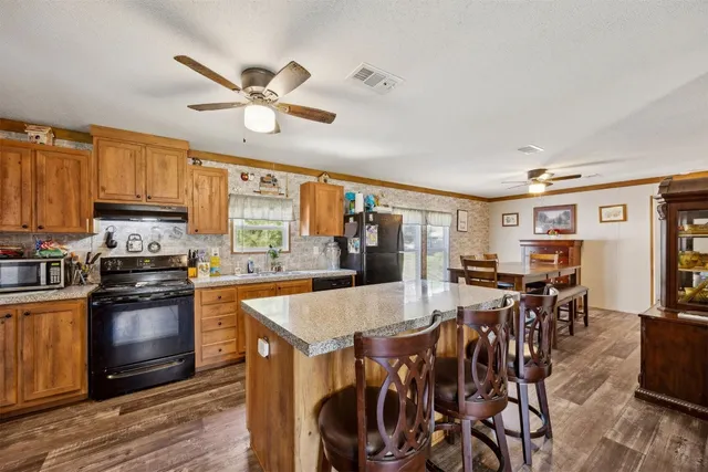 a kitchen with stainless steel appliances granite countertop a sink a stove and a refrigerator