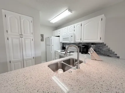 a kitchen with white cabinets and white appliances