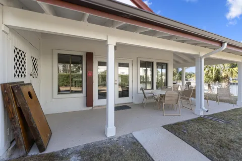 a view of a patio with a dining table and chairs with wooden floor