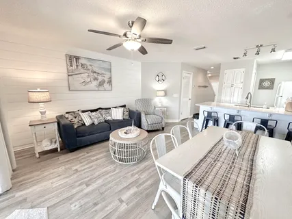 a living room with furniture a flat screen tv and a large window