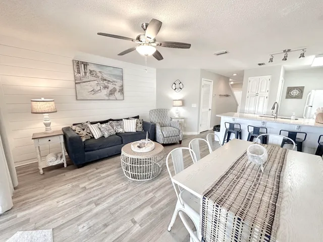 a living room with furniture a flat screen tv and a large window
