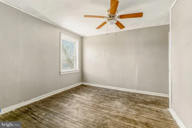 a view of a room with wooden floor and a window
