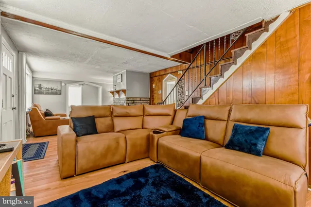 a living room with furniture a couch and wooden floor