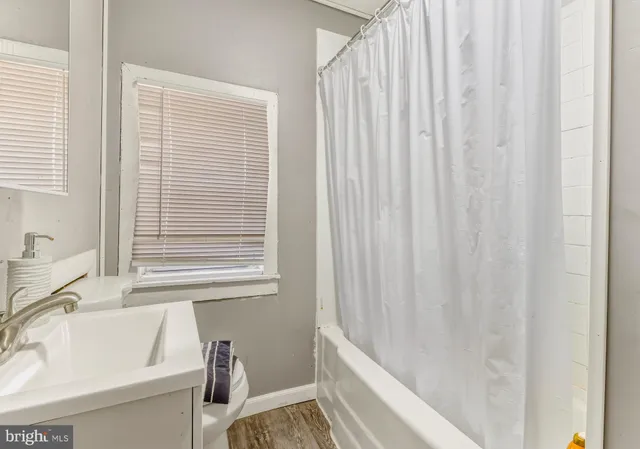 a bathroom with a sink a bathtub and a window