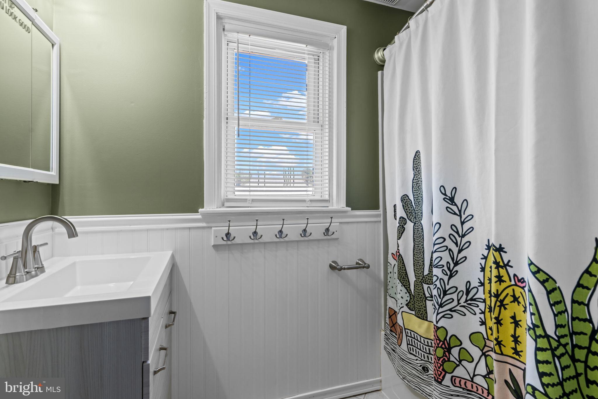 809 Millwood Road Philadelphia, PA 19115 - Photo 17 of 22 a bathroom with a sink and mirror with window