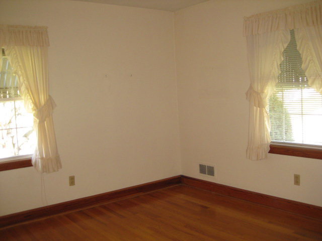 4656 Elva Road Northwest Roanoke, VA 24017 - Photo 7 of 10 an empty room with wooden floor and windows