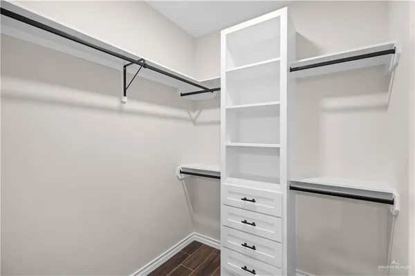 a view of walk in closet with empty racks