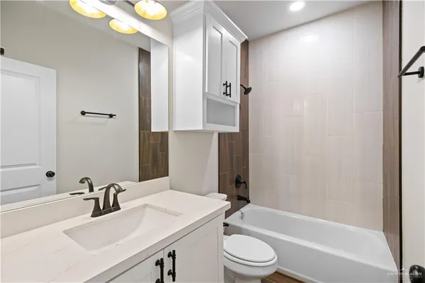 a bathroom with a bathtub shower sink vanity and toilet
