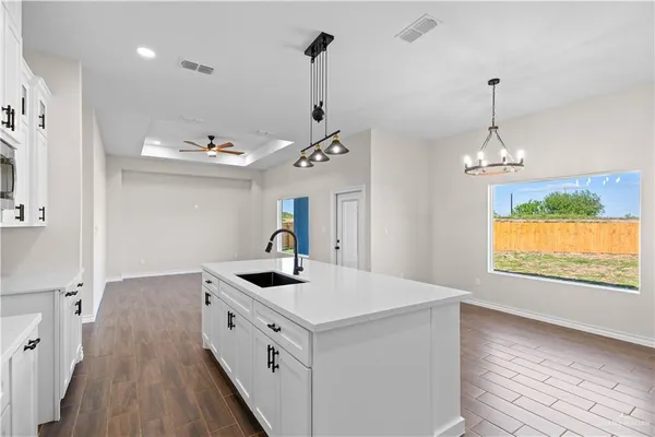 a kitchen that has a lot of countertop furniture and a wooden floor