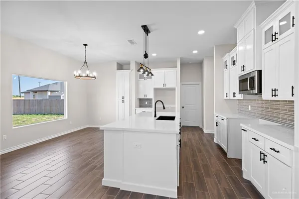 a large kitchen with cabinets wooden floor and stainless steel appliances