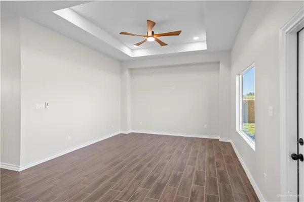 an empty room with wooden floor and windows
