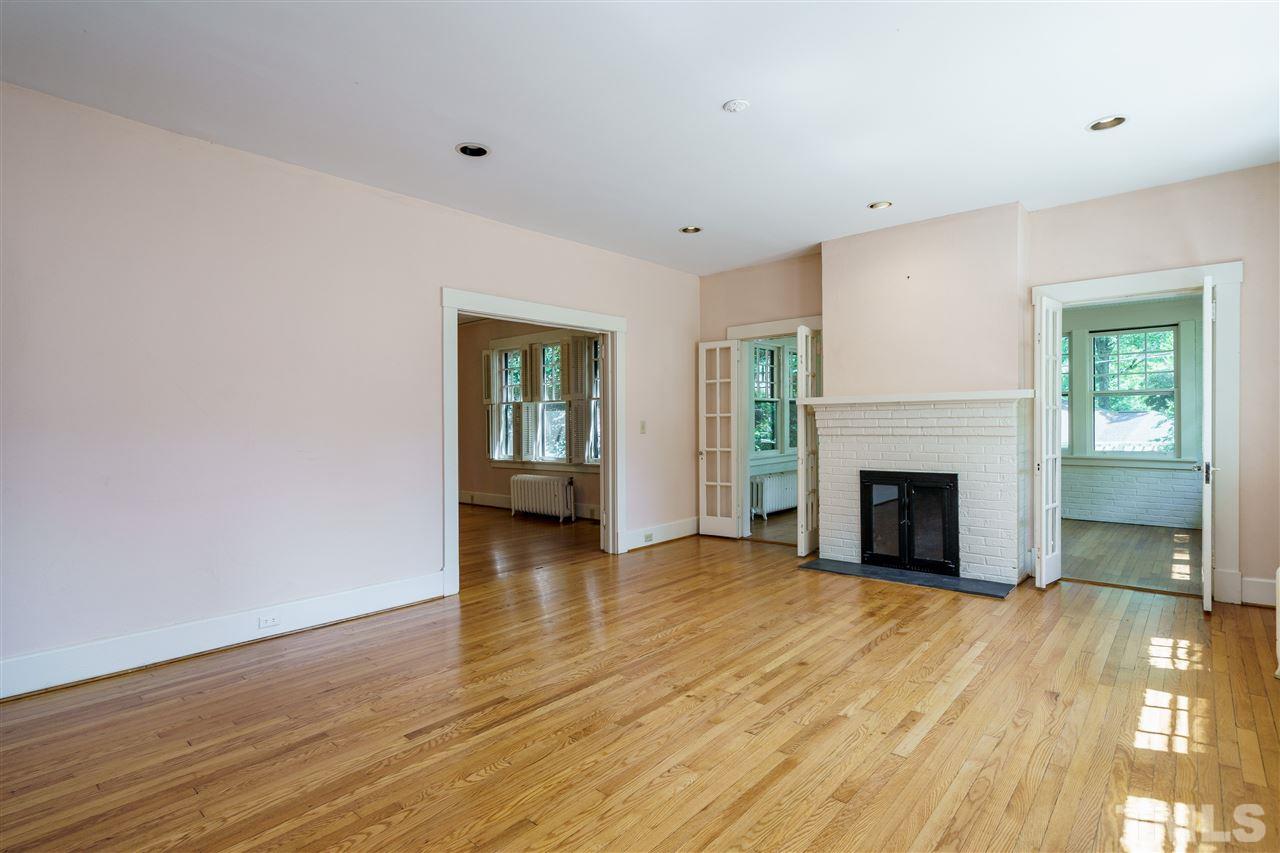 311 Hillcrest Road Raleigh, NC 27605 - Photo 6 of 30 a view of a livingroom with wooden floor and a fireplace