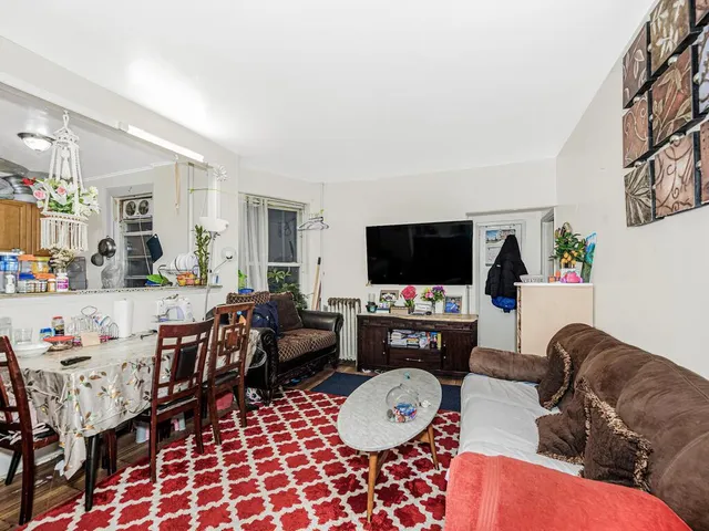 a living room with furniture a flat screen tv and a table