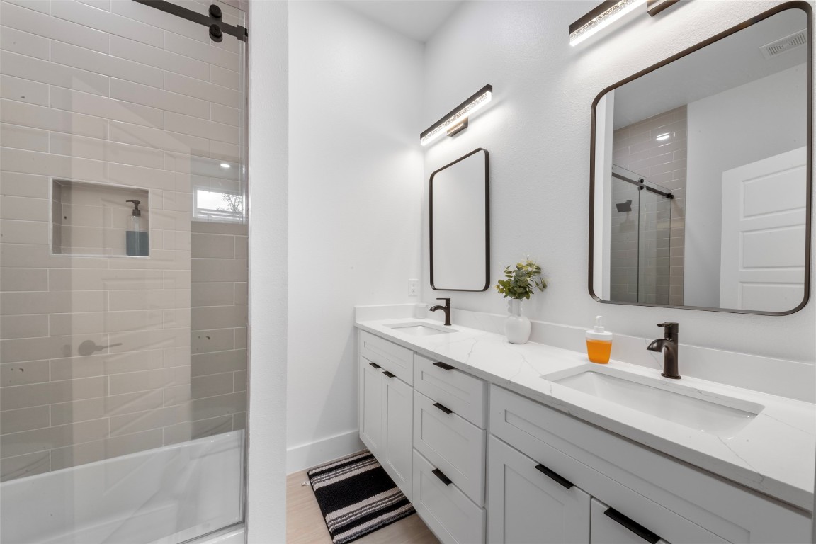 6815 Paris Street Houston, TX 77021 - Photo 17 of 30 a bathroom with a double vanity sink mirror double vanity and shower
