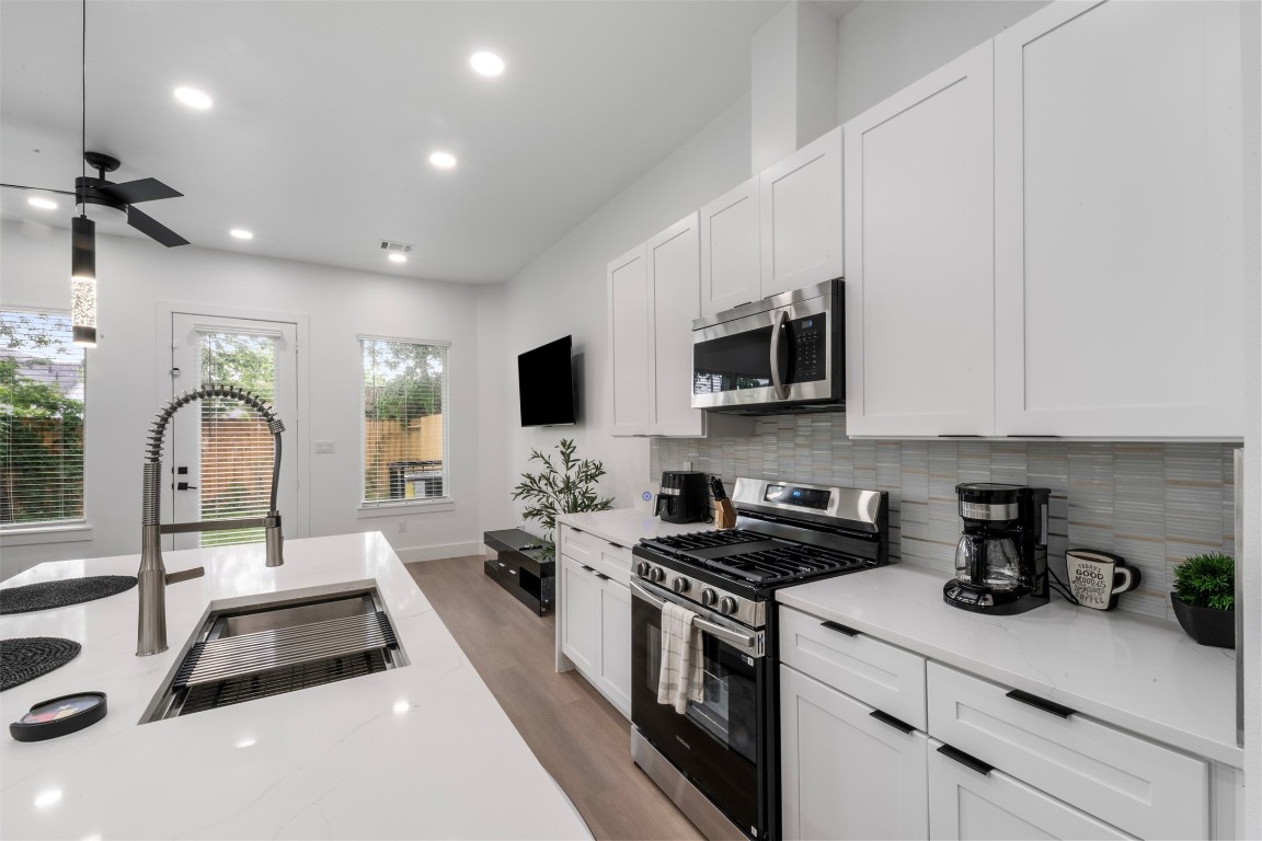 6815 Paris Street Houston, TX 77021 - Photo 26 of 30 a kitchen with stainless steel appliances a sink a stove top oven a counter space and cabinets