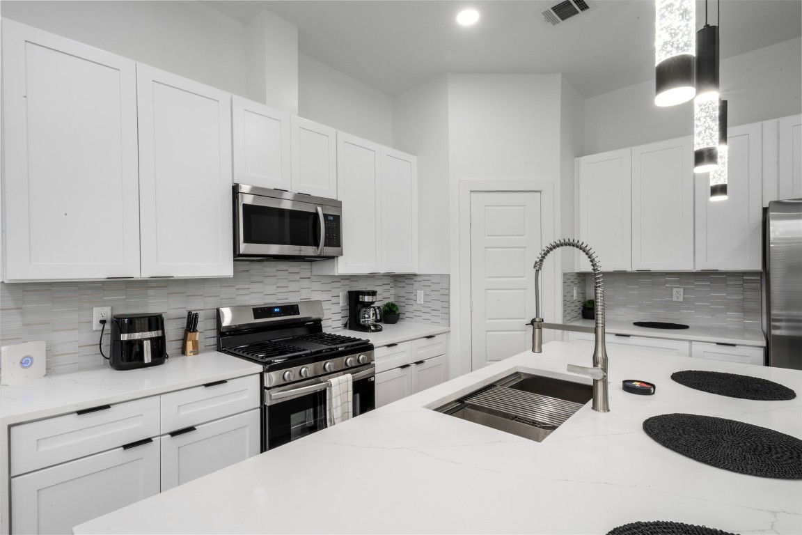 6815 Paris Street Houston, TX 77021 - Photo 27 of 30 a kitchen with granite countertop a sink a stove and microwave