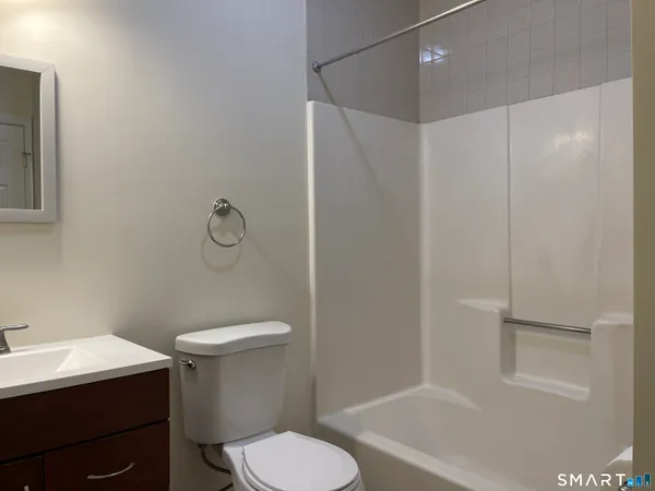 a white toilet sitting next to a bath tub