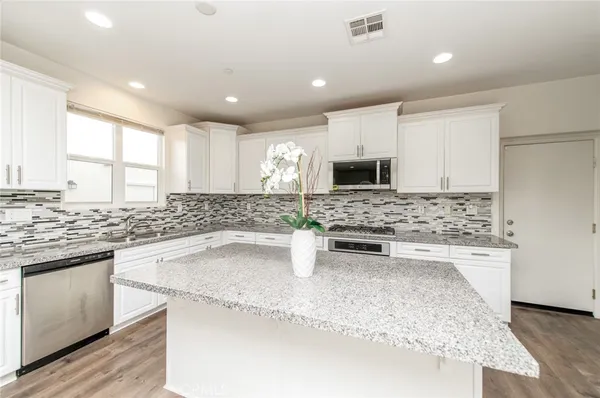 a kitchen with stainless steel appliances granite countertop a sink stove and microwave