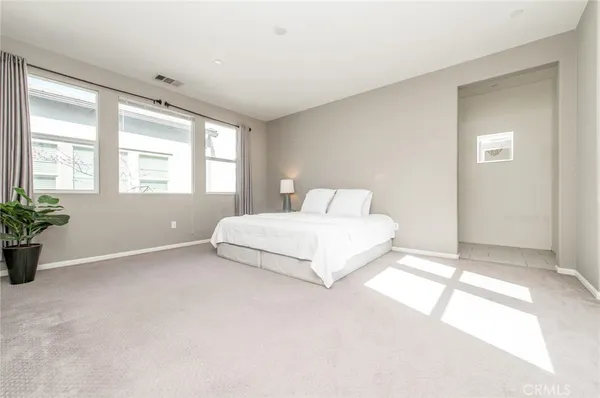 a spacious bedroom with a bed and a lamp