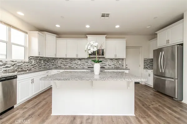 a kitchen with kitchen island a counter top space cabinets and stainless steel appliances
