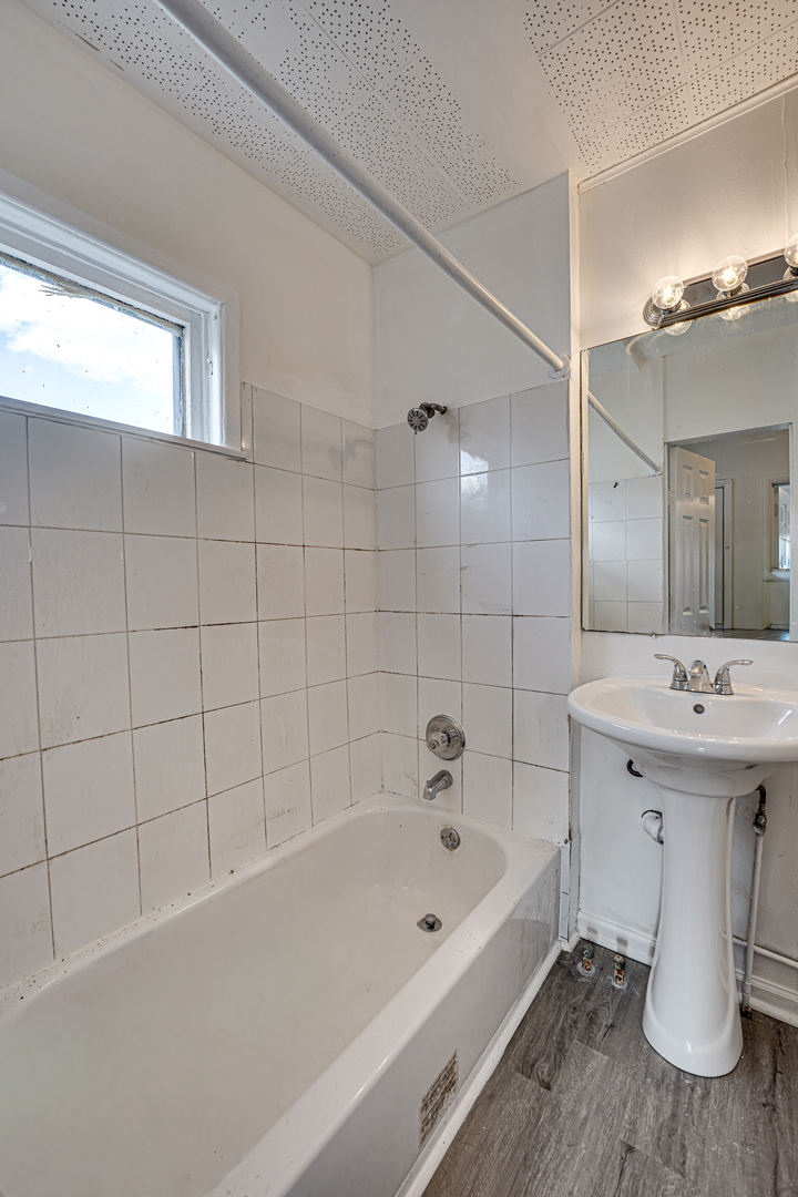 523 Grand Avenue, Unit 2 Aurora, IL 60506 - Photo 5 of 12 a bathroom with a bathtub a sink and a shower