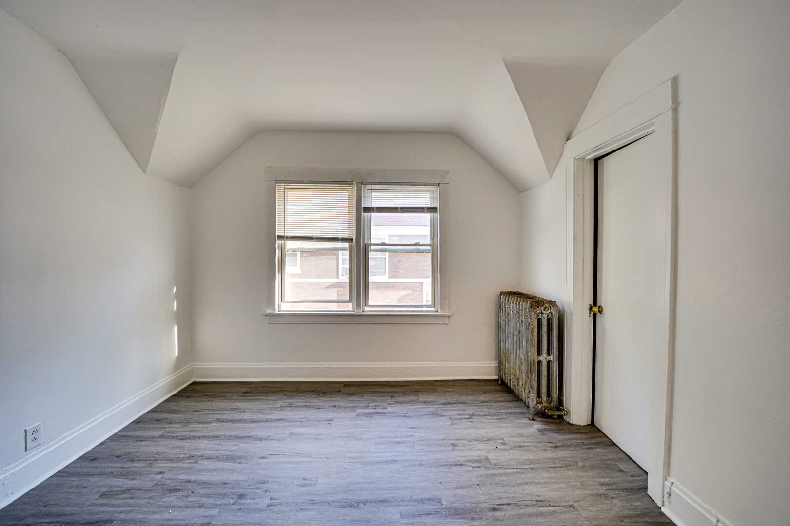 523 Grand Avenue, Unit 2 Aurora, IL 60506 - Photo 7 of 12 an empty room with wooden floor and windows