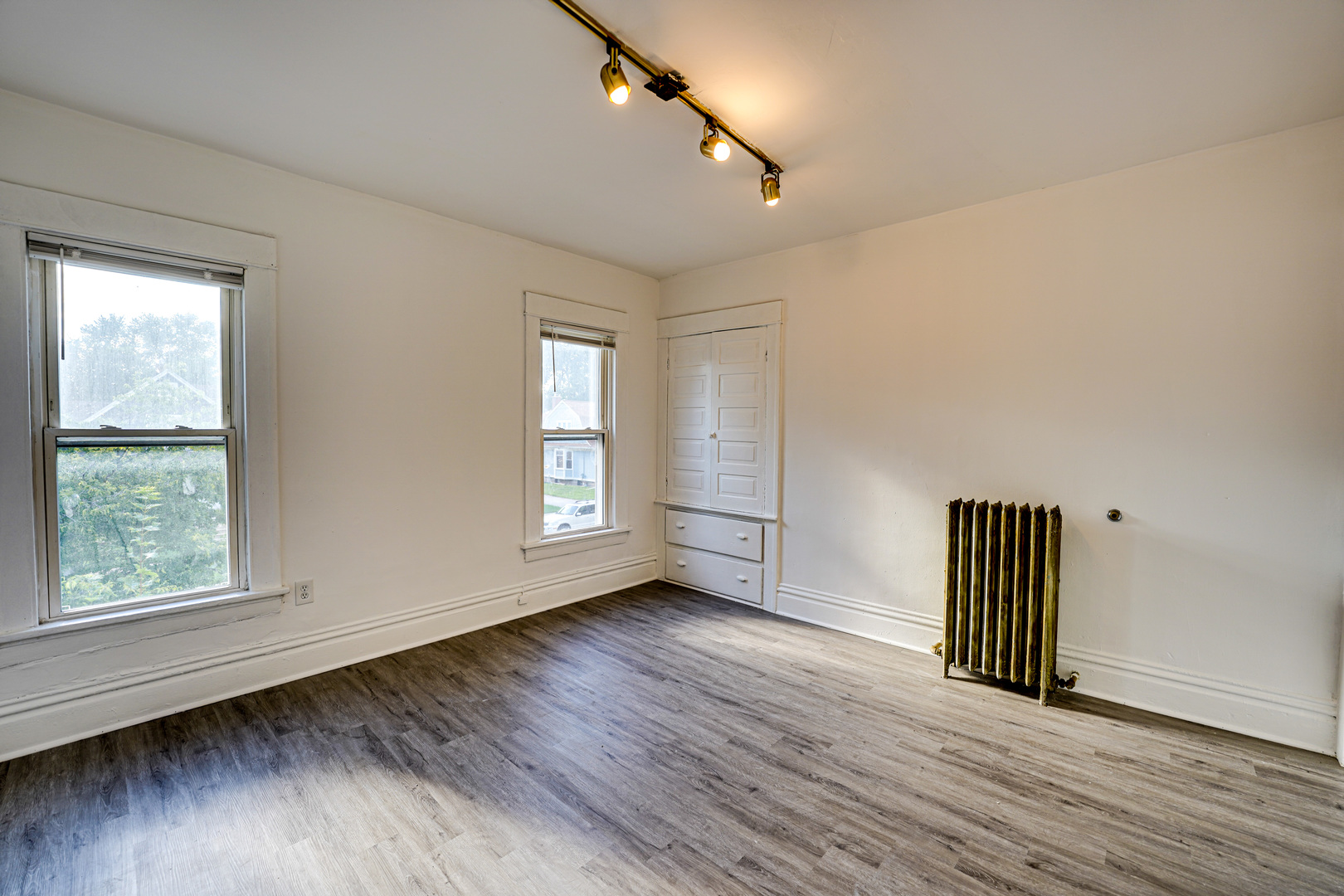 523 Grand Avenue, Unit 2 Aurora, IL 60506 - Photo 8 of 12 an empty room with wooden floor and windows