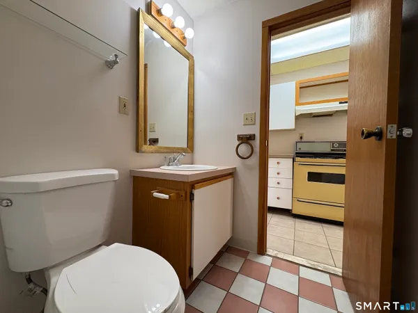 a bathroom with a toilet a sink and a mirror