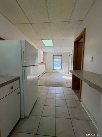 a white refrigerator freezer and a stove sitting inside of a kitchen
