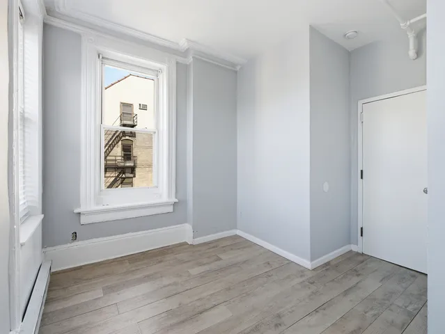 an empty room with window and wooden floor