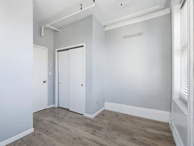 a view of an empty room with wooden floor