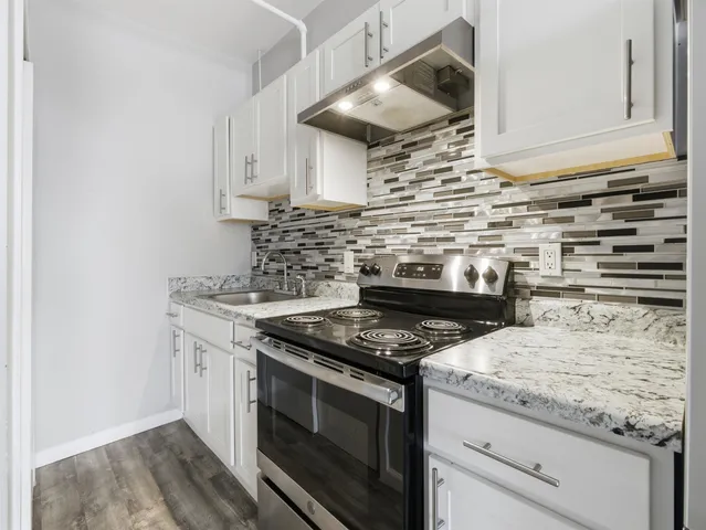 a kitchen with granite countertop a stove and a sink