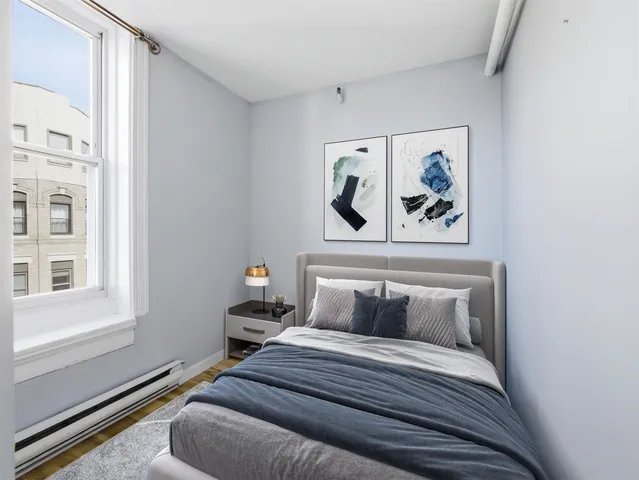 a bedroom with a bed and painting on the wall