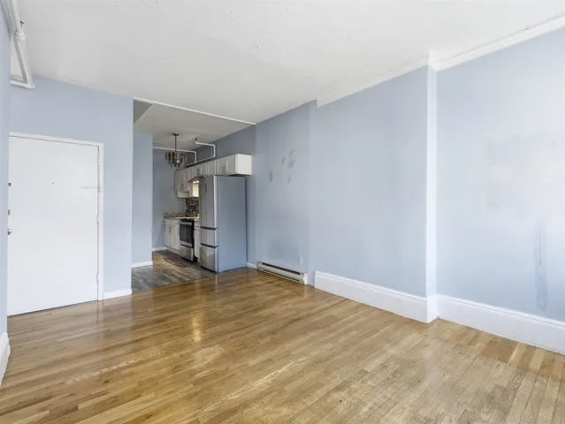 a view of empty room with wooden floor