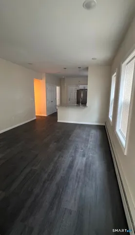 a view of empty room with wooden floor and window