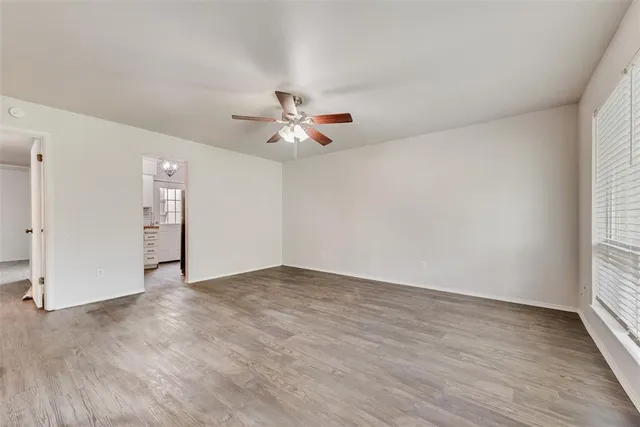 an empty room with fan and windows