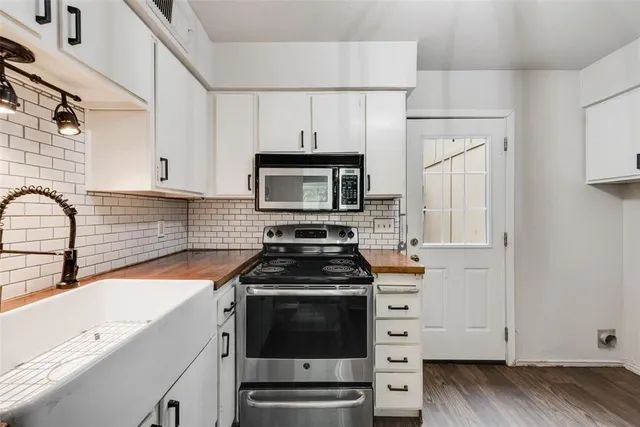 a kitchen with white cabinets and appliances
